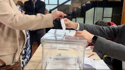  Un votante introduce su DNI en el sobre para votar 